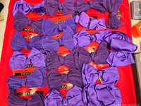 Multiple purple bow barrettes displayed on red cloth