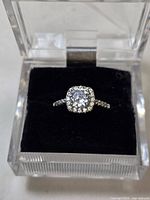 Ring in display box showing center stone and halo