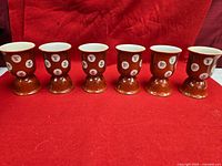 Full set of six reddish-orange porcelain pedestal cups