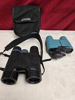 Both pairs of binoculars with case showing overall lot contents