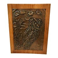 Frontal view of copper repoussé owl plaque on wood panel