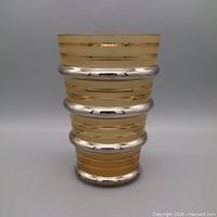Frontal full-height view of vase showing amber glass and silver bands