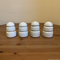 Four porcelain insulators front view