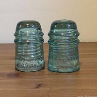 Both aqua glass insulators side by side front view
