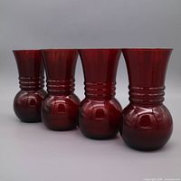 Group shot of four matching ruby red Anchor Hocking vases