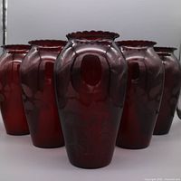 Five ruby red etched vases grouped together