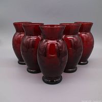 Group shot of five ruby red etched glass vases