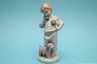 Full frontal view of porcelain figurine showing boy, teddy bear, dog