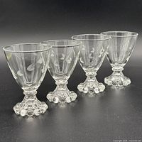 Four clear etched leaf stemmed goblets angled side view