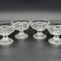 Group shot of the four pressed glass sherbet compotes lined up