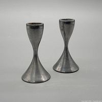 Front view of both aluminum hourglass candlesticks