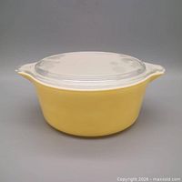 Yellow Pyrex casserole with clear lid, front view