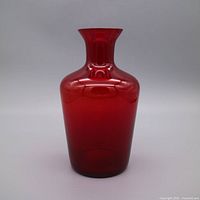 Front view of ruby red glass vase standing upright
