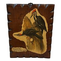Front view of carved wood plaque with bird illustration and caption