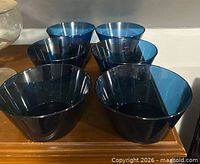 Six blue plastic bowls displayed