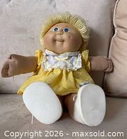 Doll seated showing front, dress details, hair, face