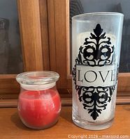 Tall LOVE glass cylinder with white pillar candle and small red jar candle side by side