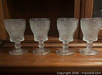 Front view of all four pressed glass goblets