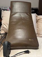 Front view of brown Wahl massage pad with attached controller and power cord visible