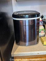 Front and side view of Frigidaire countertop ice maker showing brand logo and exterior finish