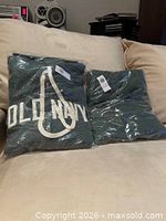 Jogging suit hoodie and pants in original plastic bags on sofa