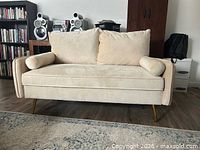 Front view of love seat showing cushions, pillows, legs