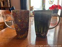 Two art print bone china mugs side by side
