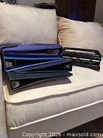 Three binders stacked with hole punch on couch