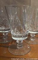 Close view of three pinwheel cut crystal wine glasses showing pattern and stem