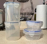 Stacked view showing two tall cylindrical containers and two shallow round containers with blue-seal lids