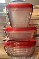 Stacked view of small, medium and large containers showing red lids and clear bodies