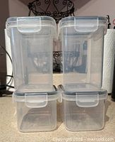 Four small square airtight containers stacked two by two