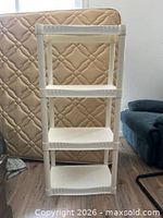 Front view of white plastic four-shelf unit