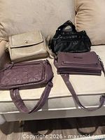 All four shoulder bags displayed on sofa