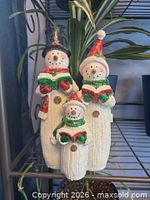 Two stacked snowmen caroler figurine sets on shelf
