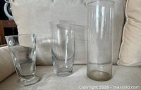 Three clear glass vases side by side showing size differences