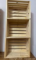 Three stacked wooden slatted crates front view