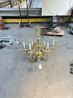 Full view of chandelier on floor showing all six arms and candle sleeves