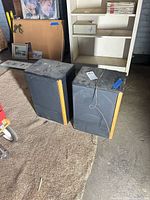 Two Advent floor speakers standing on carpeted and concrete floor