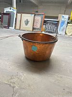Full view of copper cauldron with iron handle