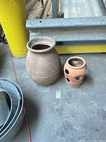 Large and small terracotta planters side by side