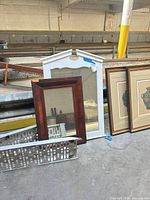 Both mirrors leaning against rail, white 45x32 in and brown 24x16 in visible