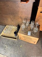 Overview of lot showing two boxes with stemmed glasses, tumblers, mug, bottle