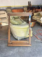 Full view of rectangular carved tiger oak mirror frame standing upright