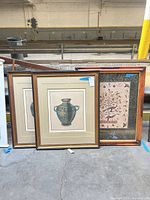 All three framed prints leaning against wall