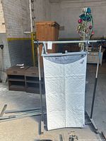 Front view of assembled pad on stand with extra poles on floor