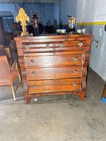Front view of dresser showing serpentine drawers, glass knobs, bracket feet