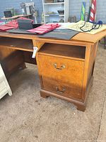 Front view showing burled drawer fronts, brass pulls, open knee space