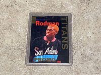 Front view of Dennis Rodman Titans promo card in holder on textured surface