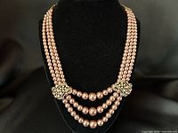 Necklace on display bust showing triple strands and ornate stations